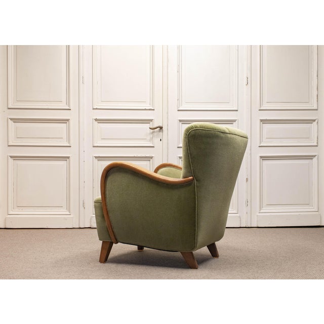 Elegant mid-century Danish lounge chair from the 1950s, executed in rich green velour upholstery. The design reflects the...