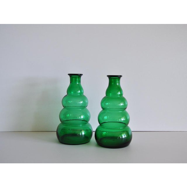 A set of green glass vases or decanters designed by Edvin Ollers and produced by Limmareds Glasbruk, Sweden, c. 1940s....