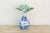 A single landscape scene, rockwork and clouds rendered in confident cobalt brushwork, wraps the lower body, left to...