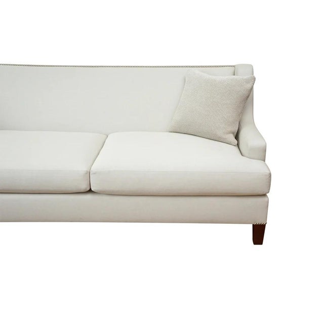 Elegant curved arm sofa in tight back with vertical top stitching and pewter nailhead trim. Tapered leg in mahogany wood...
