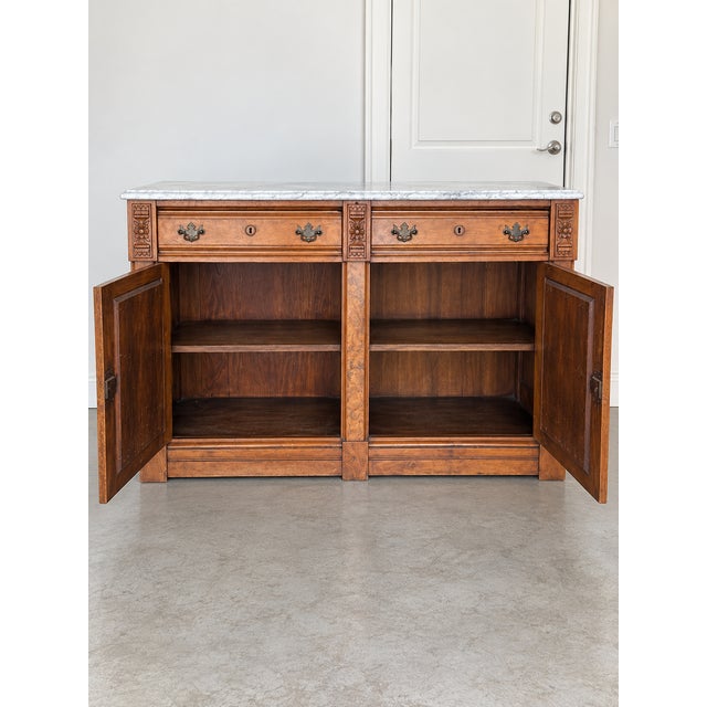 Very pretty antique carved sideboard in burled wood with two drawers (one divided) on top and two cabinets below. Brass...