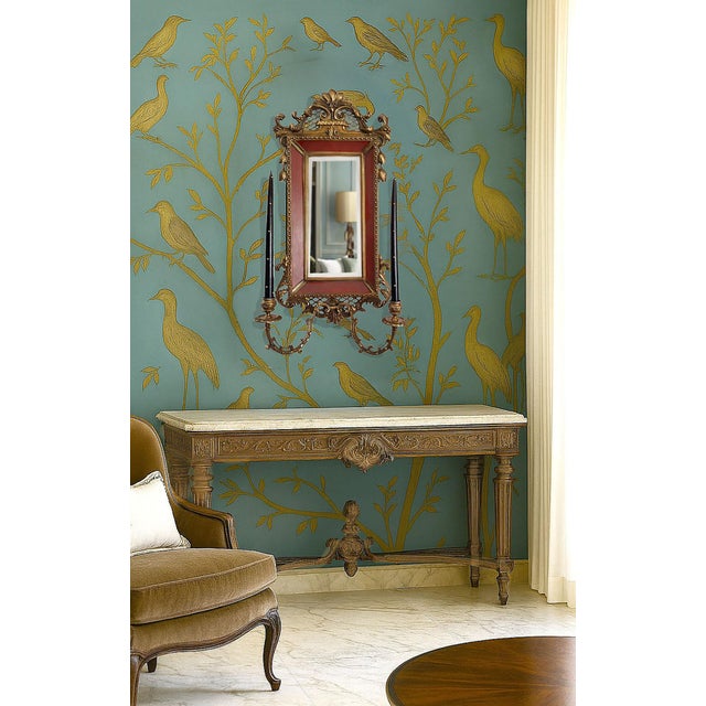 Offering a unique vintage Porcelain & Ormolu beveled wall mirror done in a French Rococo style, circa 1960s. The burgundy...