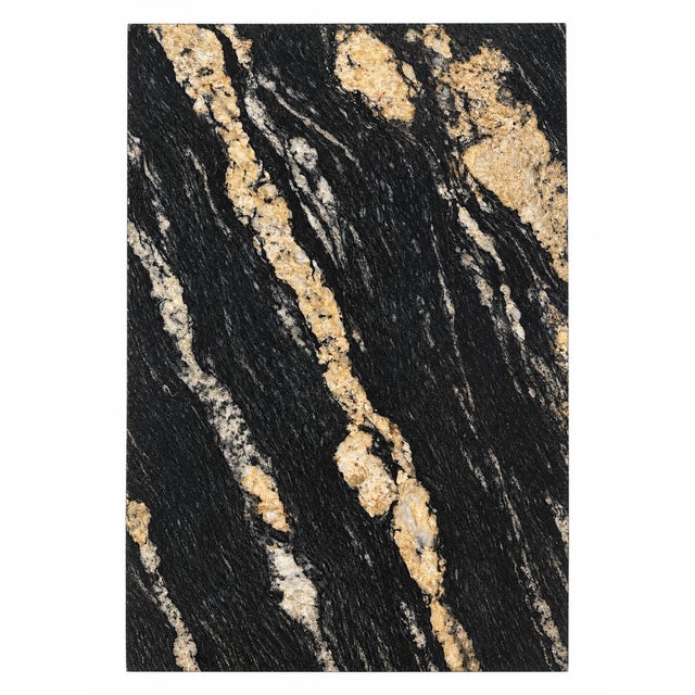 Contemporary dining table featuring an oval black veined marble top supported by textured natural stone pedestal bases...
