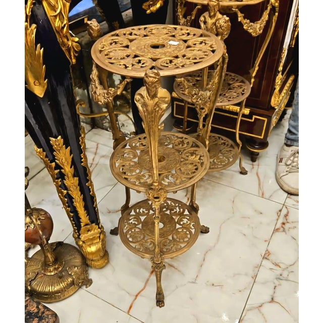 A remarkable French-inspired side table featuring an intricate three-tier design completely adorned with gold leaf...