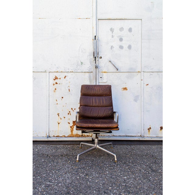 Adjustable office chair with chromed metal frame and armrests, leather-covered upholstery. Eames Soft Pad Model EA 219...