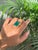 This statement cocktail ring features one bold emerald-cut natural green emerald weighing approximately 12.59 carats,...
