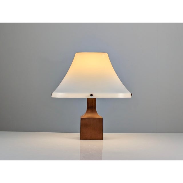 This table lamp reflects the Danish Modern design language of the 1960s, built from solid teak and molded acrylic. The...