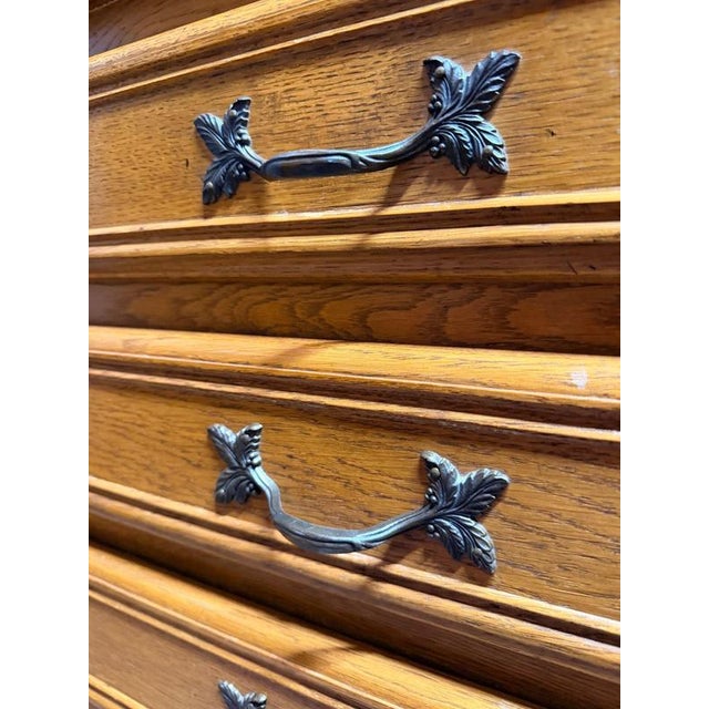 Add classic French style to any space with this lovely, compact 20th-century oak chest of drawers. Crafted with a warm,...