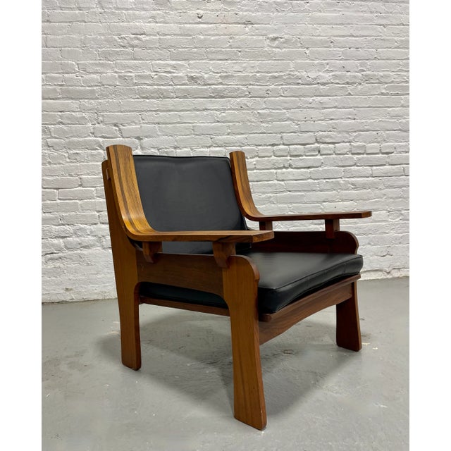 Striking Mid Century Modern sculpted lounge chair featuring beautifully grained walnut and rosewood construction and sleek...
