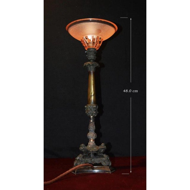 An elegant late 19th-century victorian bronze table lamp, distinguished by its richly detailed architectural base and...