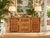 Beautiful vintage coastal cabinet featuring a natural woven rattan exterior with decorative wood trim and a rectangular...