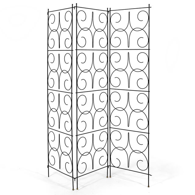 This delicate, airy design in iron with a curly scrollwork pattern has three articulating panels which help delineate...