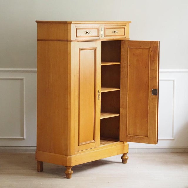 This light-colored, two-door vertical cabinet made of poplar wood dates from the second half of the 19th century, around...