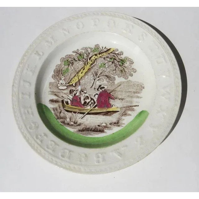 Child's alphabet plate with center image of family boating. Raised alphabet letters. Impressed mark. Measures 7" Good...