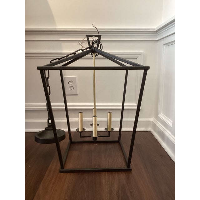 Architectural and understated, this lantern-style pendant light features a clean-lined open metal frame finished in matte...