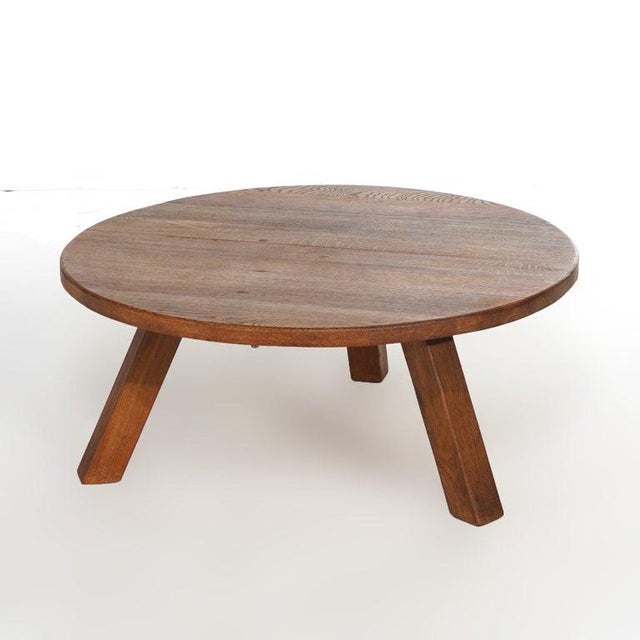 An Arts and Crafts Mission style low table offers oak construction with round top over splayed square legs, 20th century...