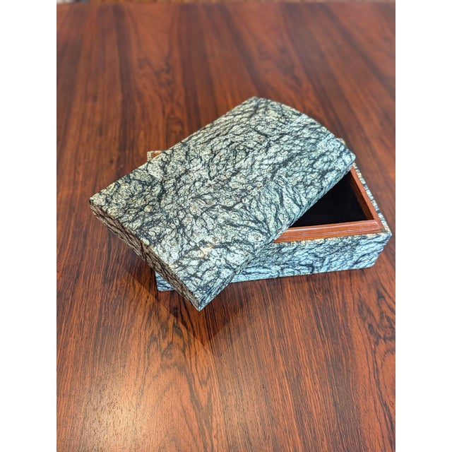 A vintage lidded decorative box made in the Philippines, its rectangular form and gently domed lid carried by a high-gloss...