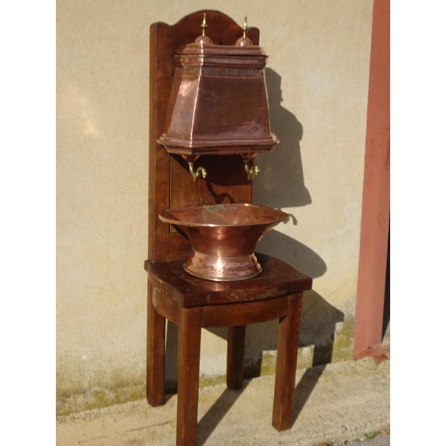 A very old, complete copper fountain, comprising a reservoir with a lid and two taps, a basin, and a large solid oak...