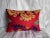 A beautifully hand-embroidered 1900s Suzani pillow featuring golden scroll motifs and deep violet floral accents on a rich...
