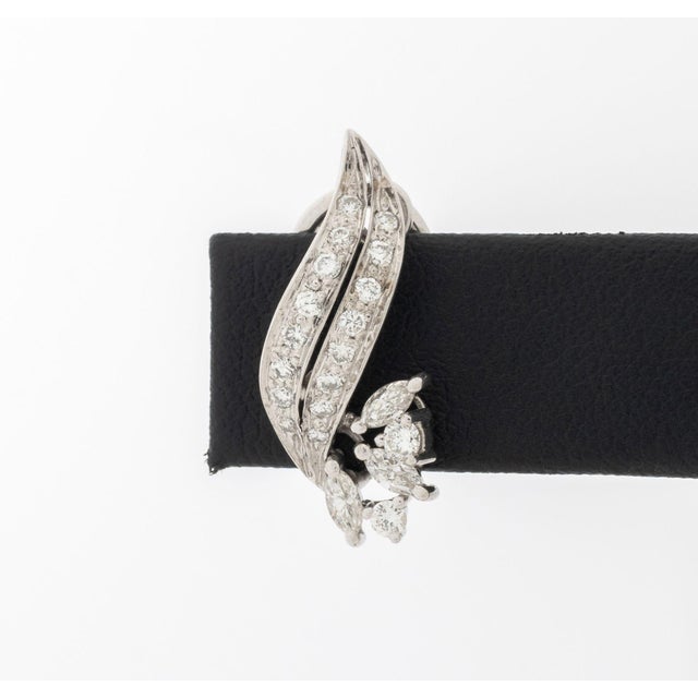 Pair of 18K White Gold and Diamond Earrings, designed as floriforms, adorned with thirty six pave and prong set round...