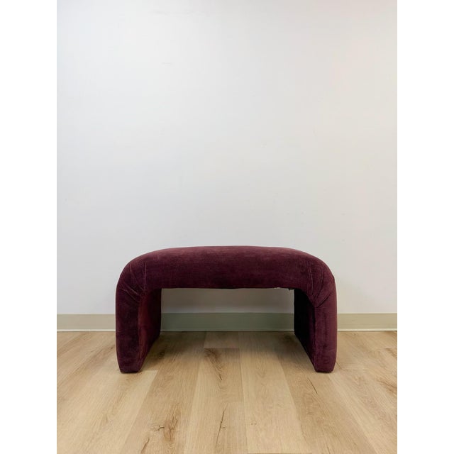 This burgundy/mauve upholstered bench brings a bold, sculptural presence to any room, embodying the confident, form-driven...