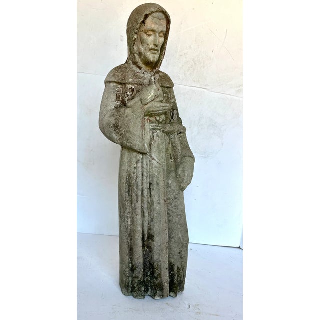 Vintage concrete statue of beloved Saint Francis of Assisi. Known for love of animals, there is a bird in one hand and a...