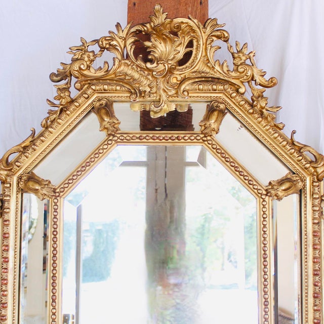 An eye-catching confection of Rococo decorative elements, combined in a cushion mirror with sober classical architectural...