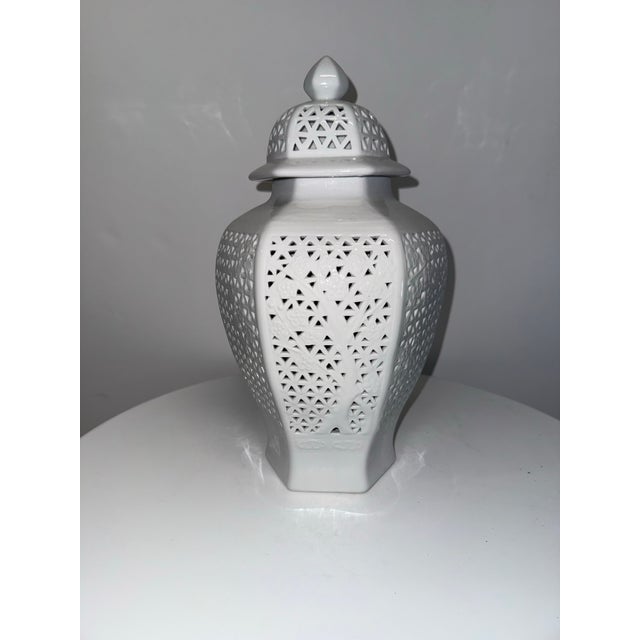 Blanc de chine reticulated ginger jar features cherry blossom motif. Hexagon vessel with lid has an elegant shape as it is...