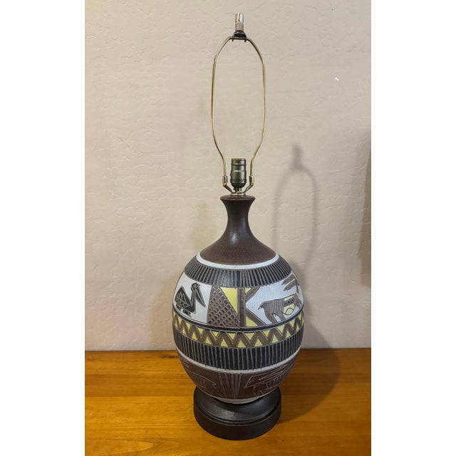 Mid century sgraffito pottery lamp incised with folk art style birds and antelope type animals, with textural pattern...