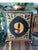 Charming vintage folk art table lamp featuring a hand-painted “No. 9” framed by ornate gilt scrollwork on a brown scroll...