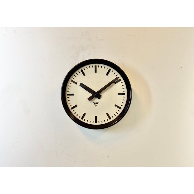 This wall clock was produced by Pragotron in former Czechoslovakia during the 1960s. It features a brown bakelite frame...