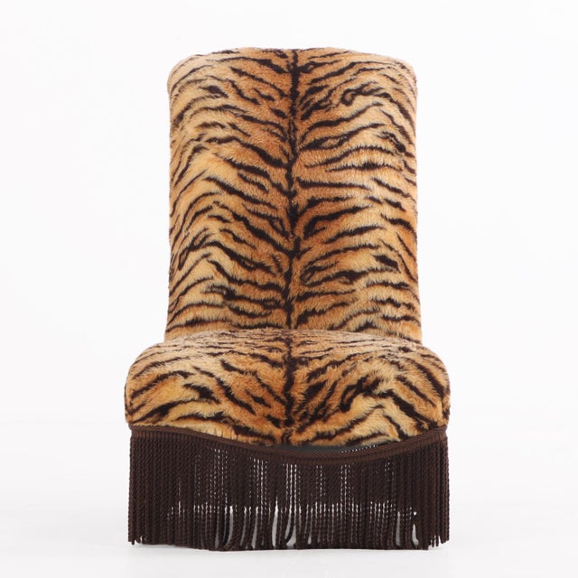 A simple back stool style chair featuring a straight, rolled crest and upholstered in a striking faux tiger fabric. The...