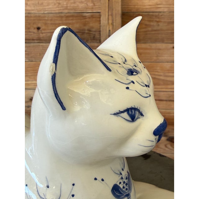 A charming and highly decorative vintage Italian ceramic cat sculpture, hand-painted in classic blue and white and resting...