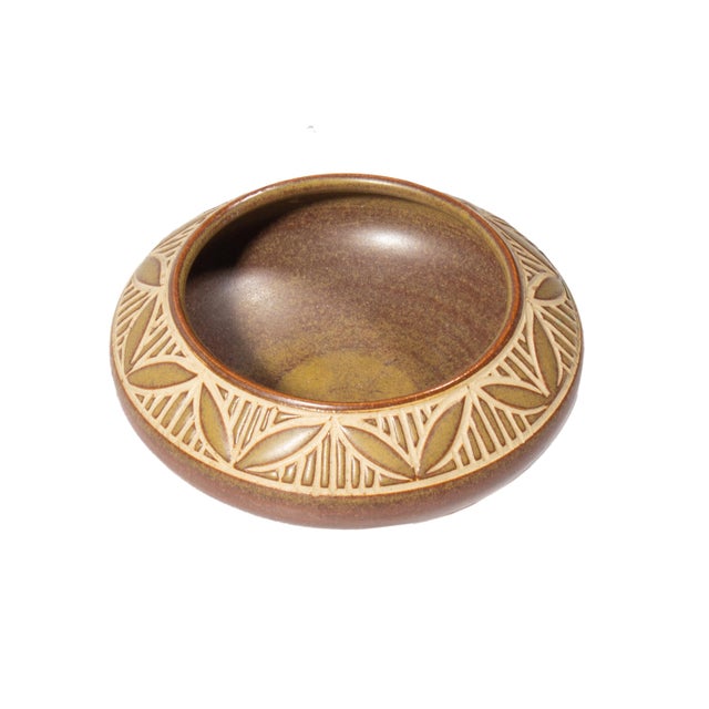 A miniature pottery vessel produced by Humlebaek Keramik. Made in Denmark, this vessel features brown glaze and a leaf...