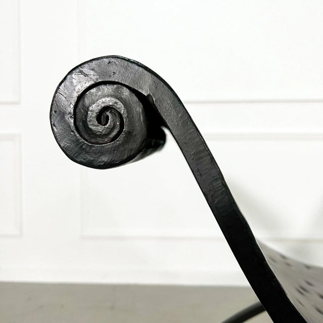 Sculptural U or Curule form bench in hand forged iron with twisted details and scrolled arms. Faux ostrich metal seat....