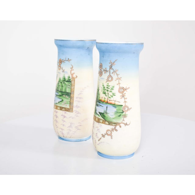 Pair of glass vases, with wide mouth. Decorated with a landscape with trees, a house and a lake in a frame with flowers...