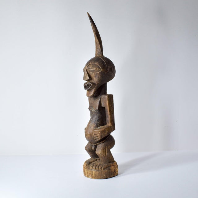 This intricately carved Songye standing figure exemplifies the distinctive artistic style of the Songye people,...