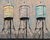 Towers Three by Stephanie Hartshorn | Oil Painting of three water towers on stilts For Sale