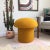 A handmade mushroom shaped ottoman, upholstered in a mustard yellow colored curly boucle fabric. Perfect for using as a...