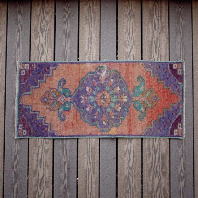 This vintage Oushak mat features a striking oversized central medallion balanced by vibrant stepped corner motifs,...