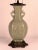 A beautiful Japanese celadon porcelain table lamp featuring raised apposing foo dog figures, mounted on an exceptional...