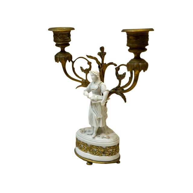 A French double arm candlestick with a bisque figure of a woman with bronze dore fittings. It is late 19th century, France.