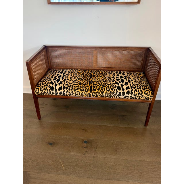 Vintage Hollywood Regency cane-back bench reupholstered in Ballard Designs’ iconic jaguar-print fabric. A chic statement...