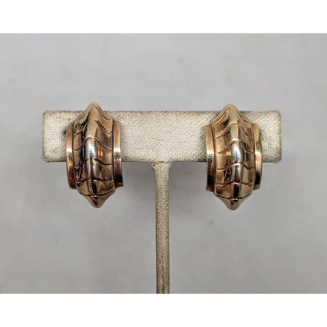 1948 goldtone with raised center and chevron design clip earrings. Marked crown "TRIFARI" on the clips and "PAT PEND COPR"...