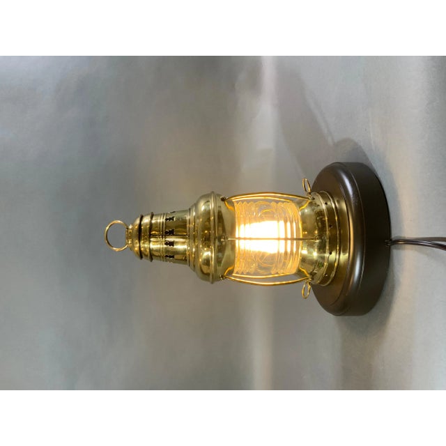 Ships anchor lantern on base. Highly polished and lacquered ships anchor lantern with Fresnel glass lens protected by six...