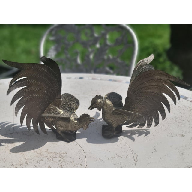 Collector's pair of vintage mid-century brass fighting rooster figurines, this pair features detailed, layered tail...