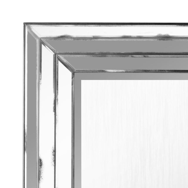 An Art Deco style mirror featuring a bold, architectural presence with a stepped, multi-layered frame composed of beveled...