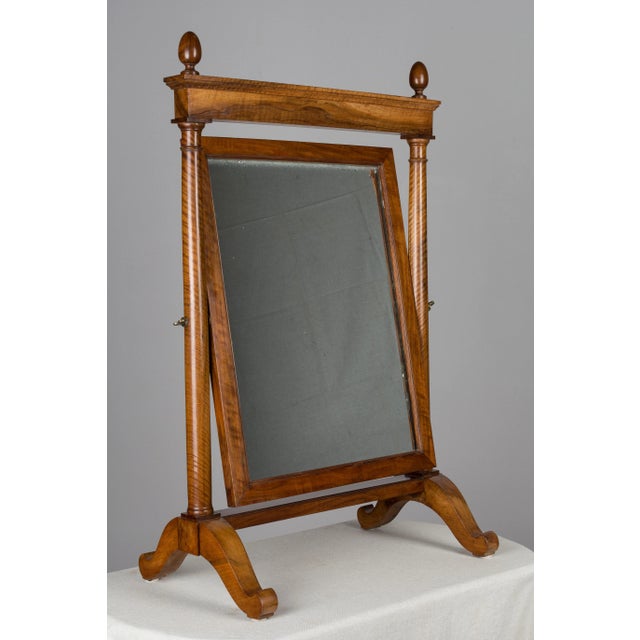 A 19th century French Empire Period cheval, or psyche mirror, crafted from solid walnut with a distinctive wood grain and...