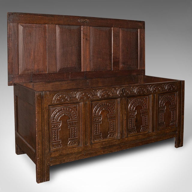 This is a large antique 4 panel coffer. An English, oak carved trunk or window seat, dating to the William III period,...
