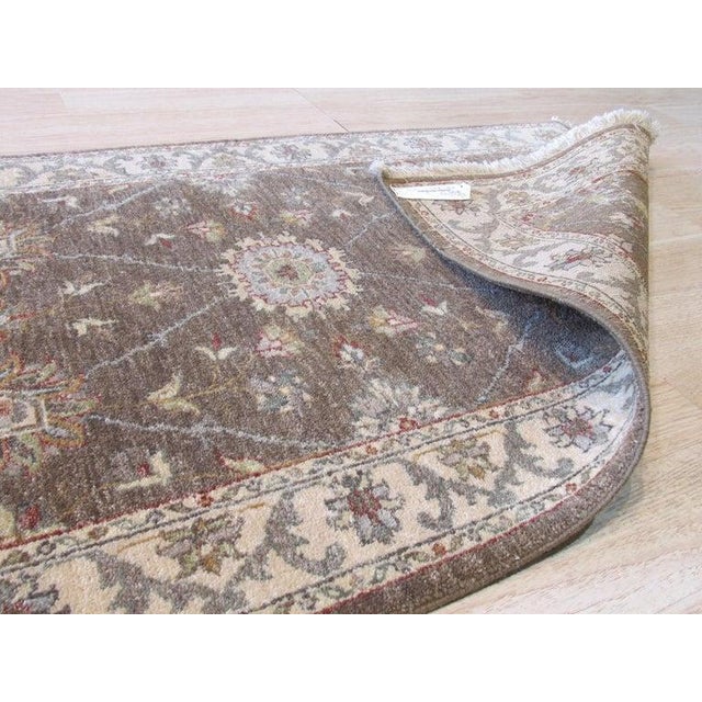 This hand knotted pile rug features a brown earth tone palette and is crafted entirely from wool. Modeled after the Agra...